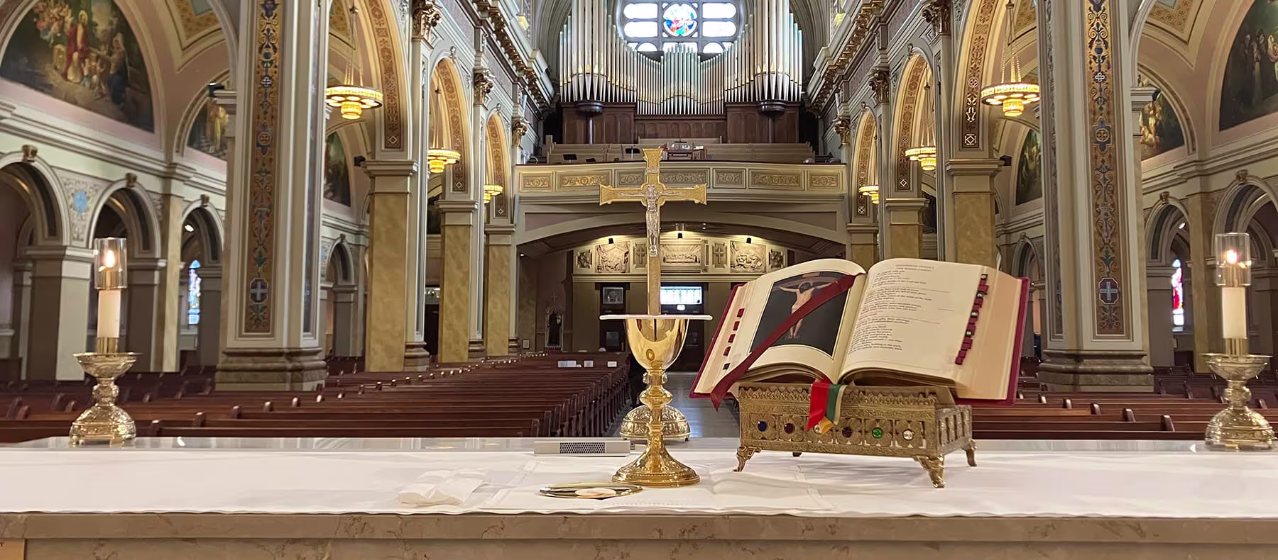 Catholic Books by MTF - Photo of the inside of a church with a view behind the alter with a Roman Missal from MTF opened.